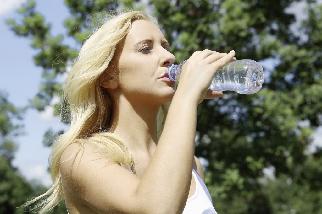 Frau trinkt aus einer Wasserflasche