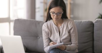 Frau sitzt auf dem Sofa bei der Arbeit