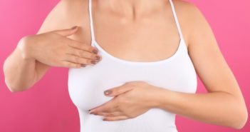 Frau tastet ihre Brust auf Brustkrebs ab
