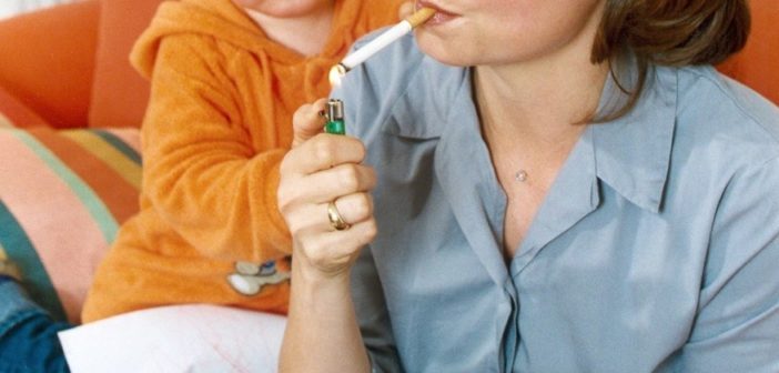Frau rauchend neben einem kleinen Kind