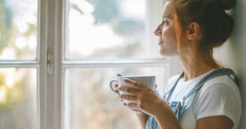 Frau schaut zufrieden aus dem Fenster © Dexcom