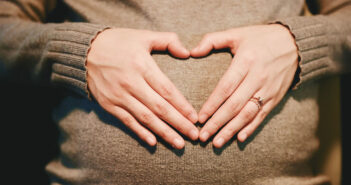 Schwangere Frau hält die Hände zu einem Herz geformt vor ihren Bauch. Pixabay
