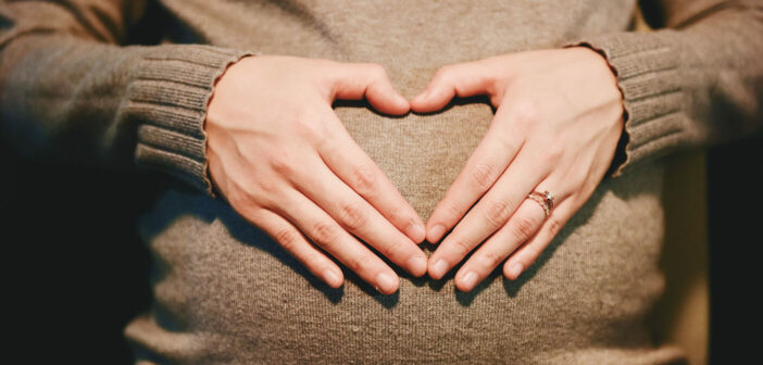 Schwangere Frau hält die Hände zu einem Herz geformt vor ihren Bauch. Pixabay