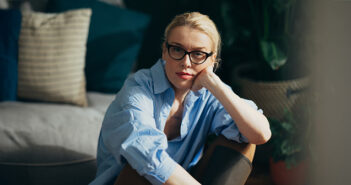 Eine Frau sitzt auf dem Boden und schaut in die Kamera