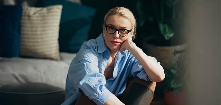 Eine Frau sitzt auf dem Boden und schaut in die Kamera