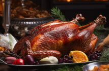 Ein gebratener Truthahn steht angerichtet auf einem weihnachtlich geschmückten Tisch